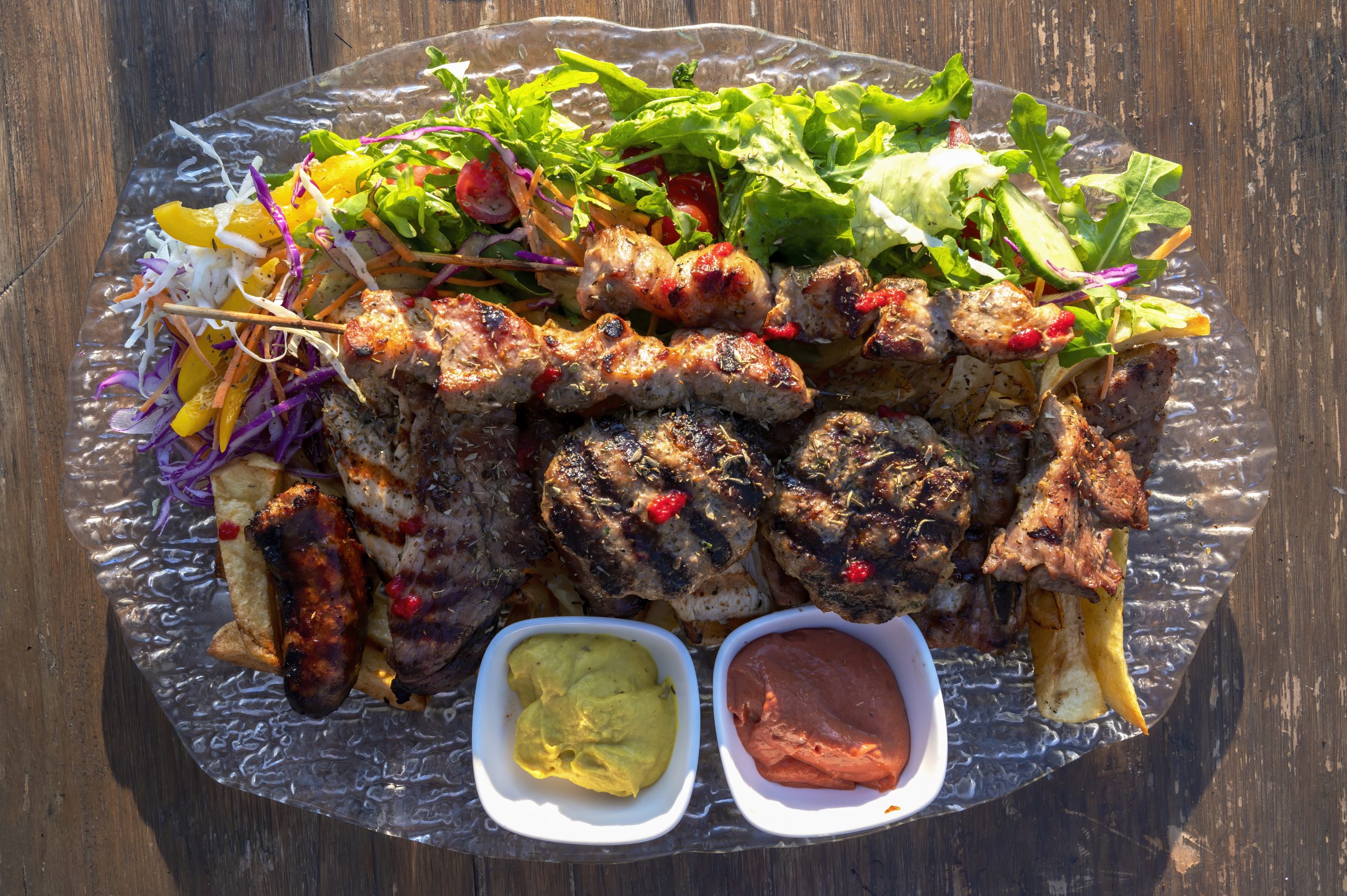 BBQ with toppings and sausages on a dish on open air